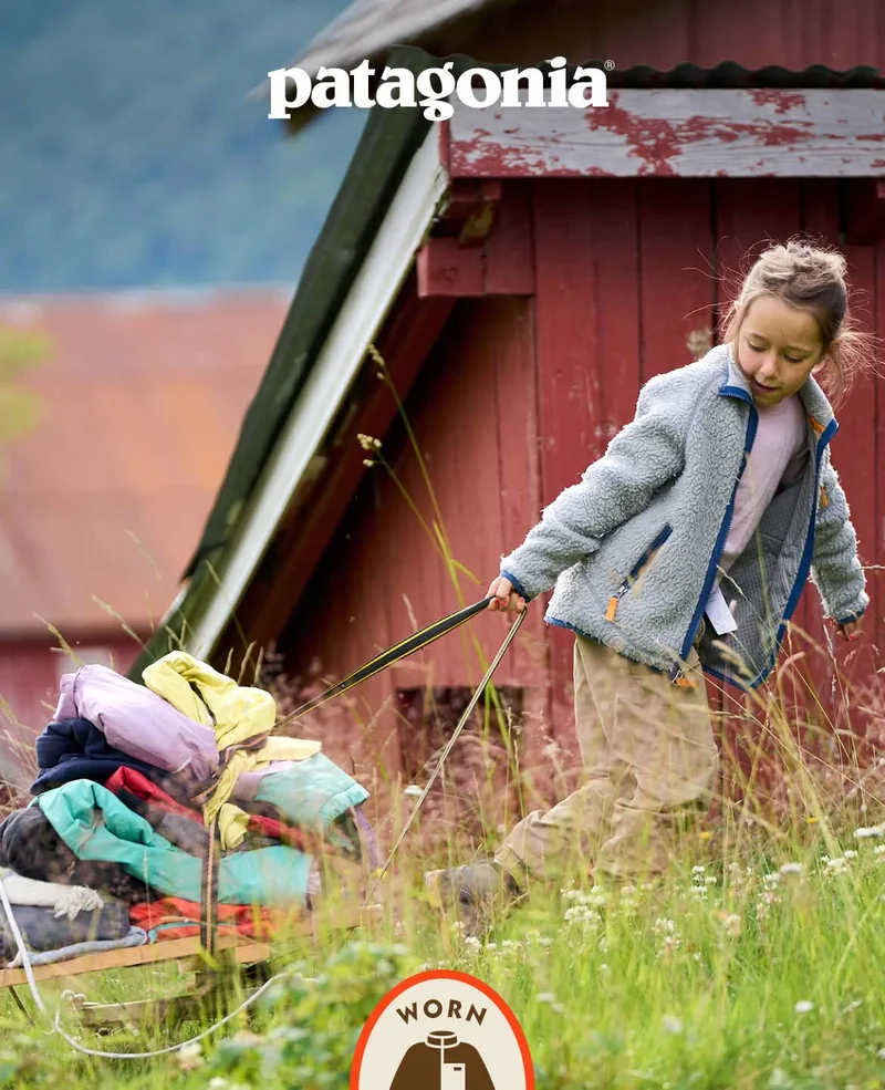 Patagonia. A child pulls a handmade go-kart stacked with clothes.