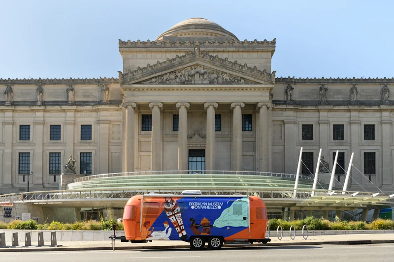 A brightly painted Airstream trailer sits in front of the Brooklyn Museum