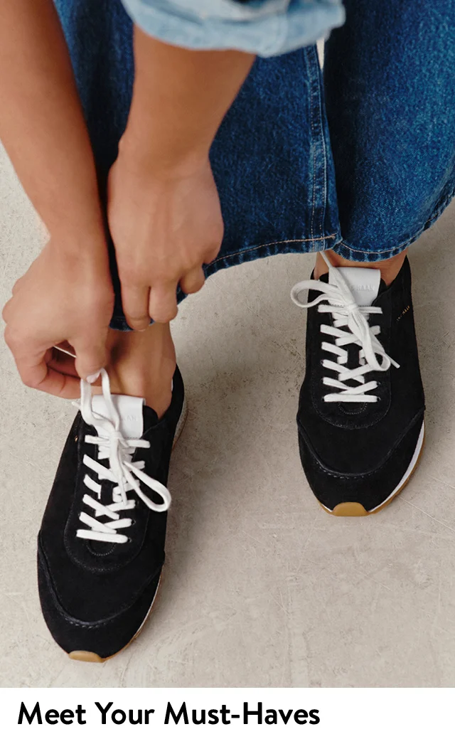 A woman wearing black sneakers with jeans.