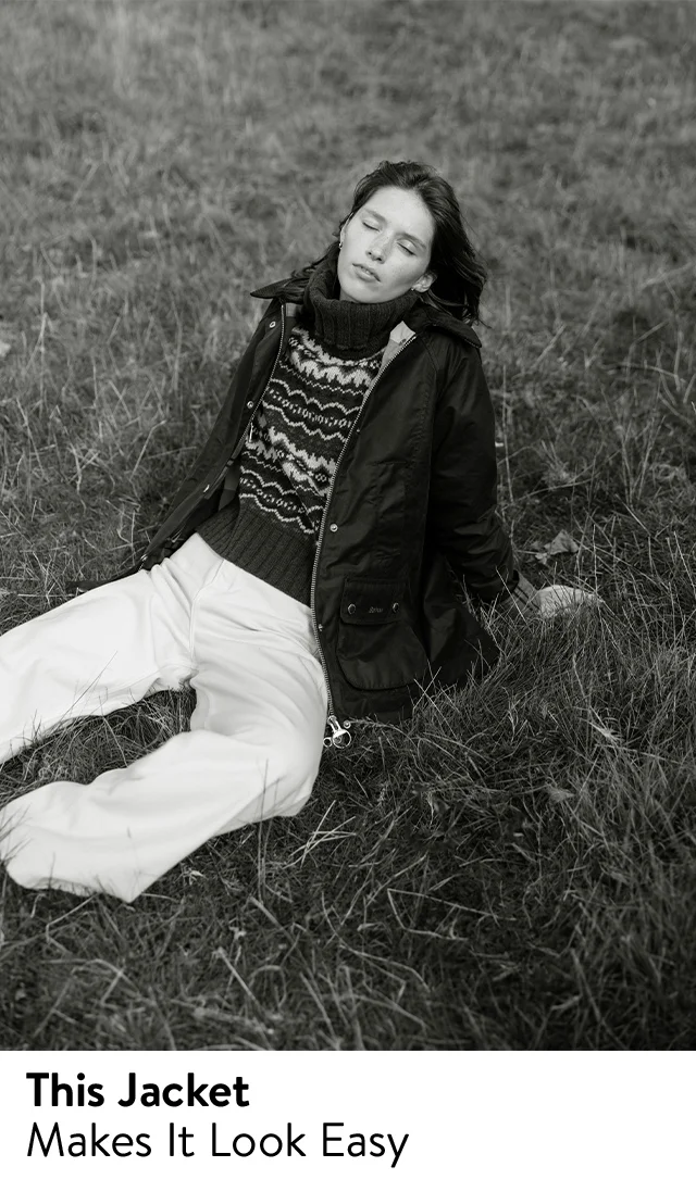 A woman wearing a jacket with a sweater and pants.
