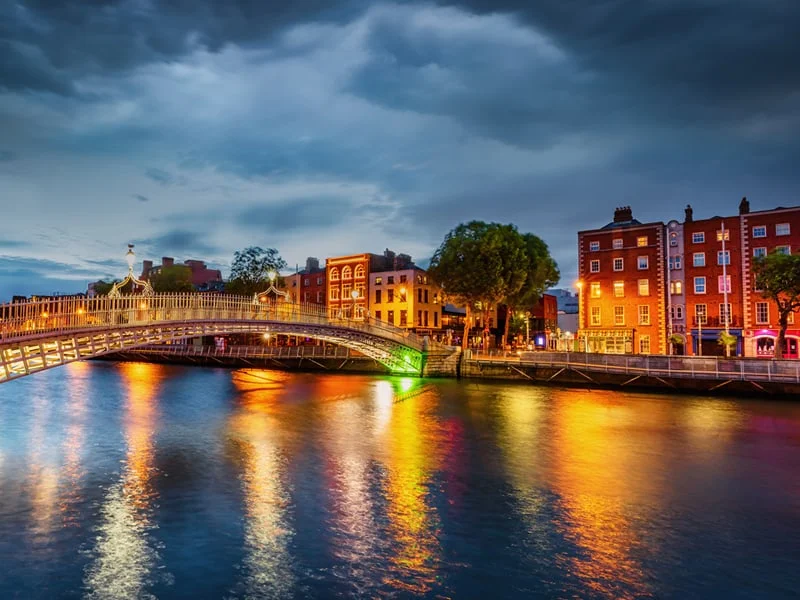 Panorama of vibrant Illuminated Ha'penny Bridge Landmark over the river Liffey in Dublin, Ireland.