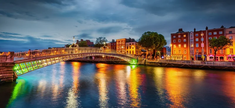Panorama of vibrant Illuminated Ha'penny Bridge Landmark over the river Liffey in Dublin, Ireland.