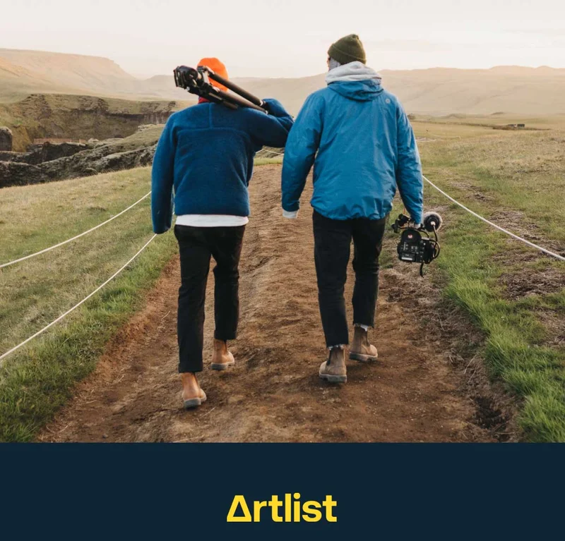 Image of two creators walking through a valley with camera gear in hand.