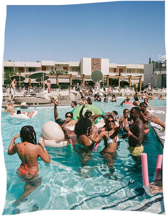 A group of people in bathing suits, enjoying the pool at a midcentury modern hotel