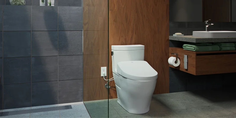 A TOTO Legato WASHLET+ S550e bidet toilet in a masculine bathroom next to a shower with slate tile walls