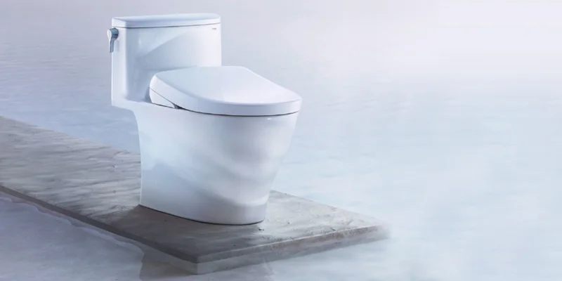 A TOTO Nexus WASHLET+ S7A bidet toilet on a wooden platform over clear blue water
