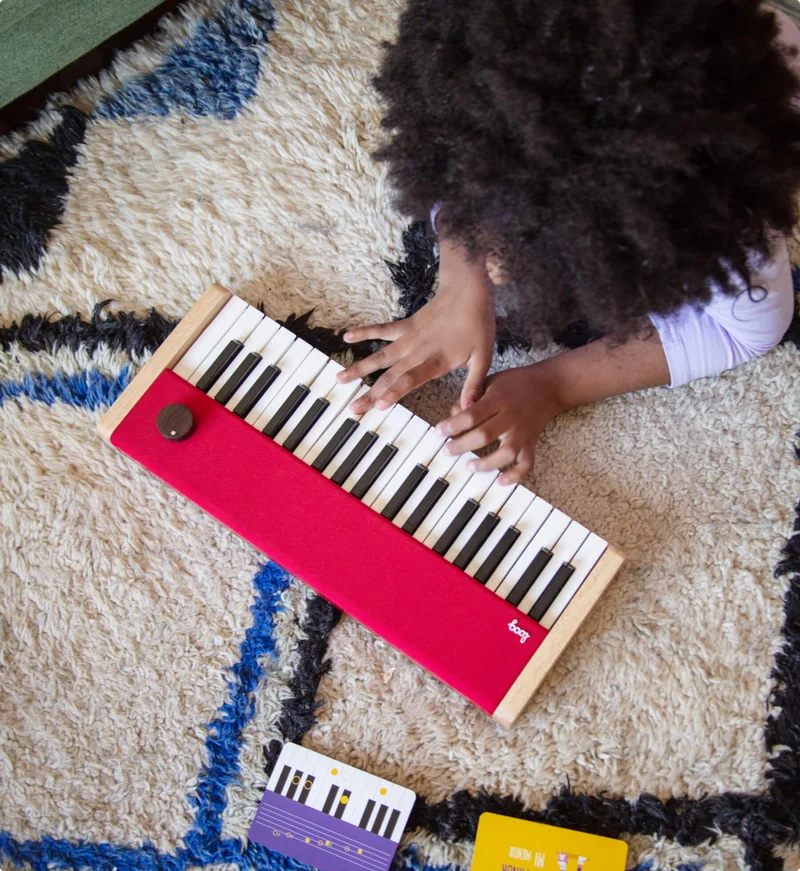 girl playing loog piano