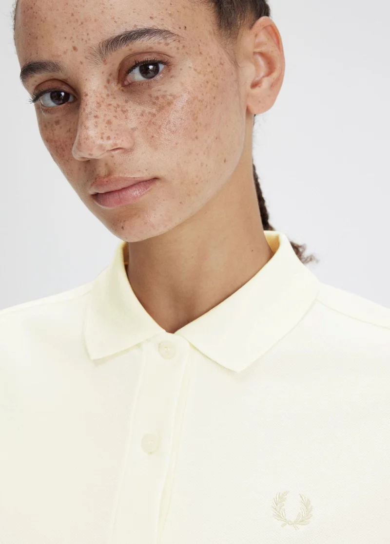 Female model wearing an ecru Fred Perry Shirt
