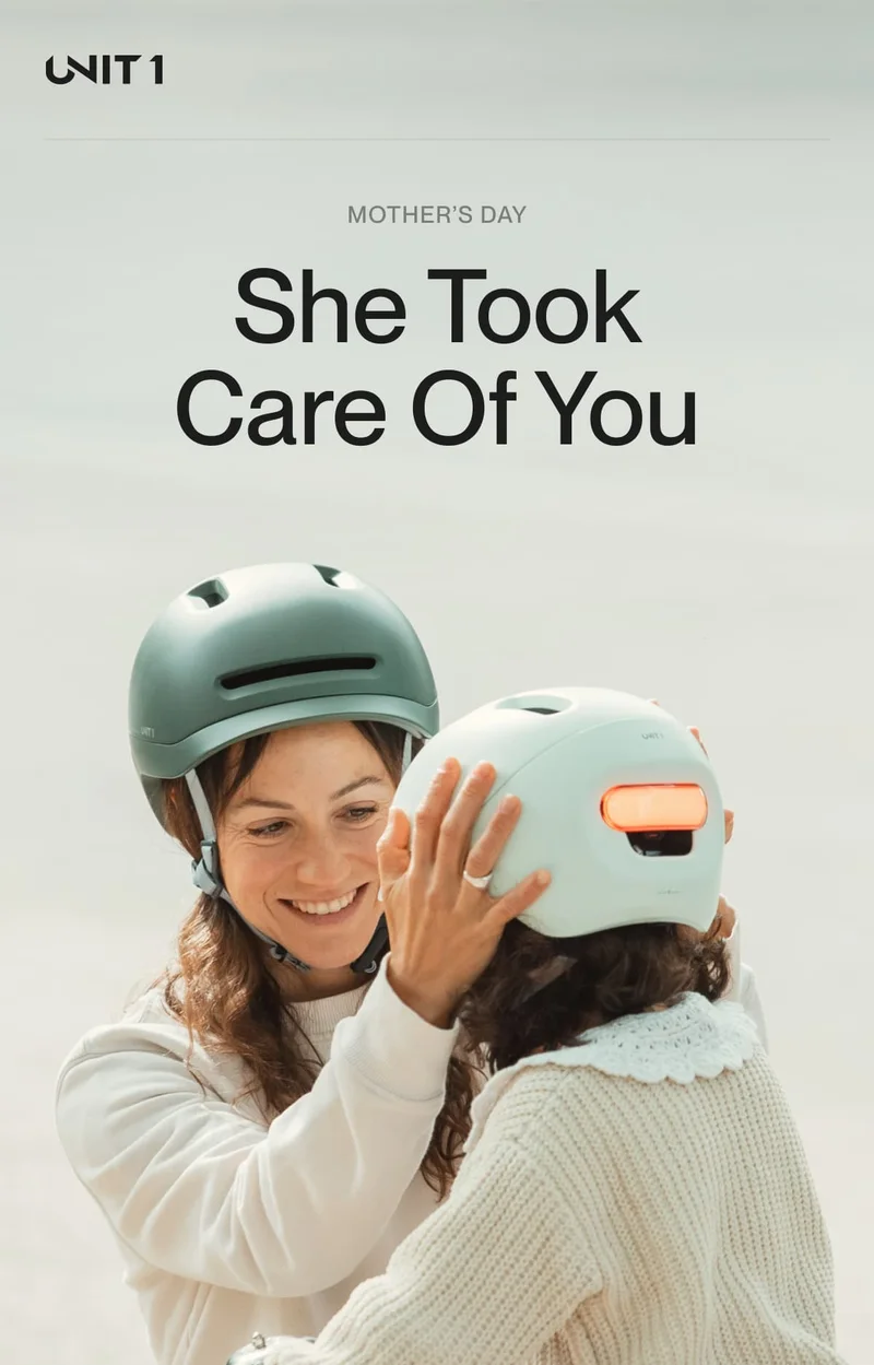 Mother helping her daughter wear a UNIT 1 smart helmet. “She Took Care Of You” headline for Mother’s Day campaign.