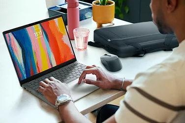 Over-shoulder view of a person working on a Dell 14 Plus computer in an office setting.