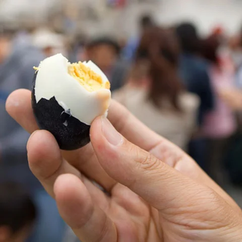 An egg with a black exterior and hard whites and yolk.