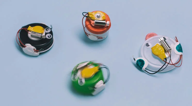 Bottle Cap Bots: Image of four small bots made from bottle caps and wires.