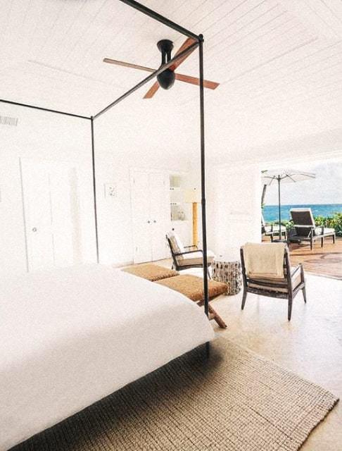 Image Description: A minimalist hotel room interior with an outdoor deck that offers views of the sea
