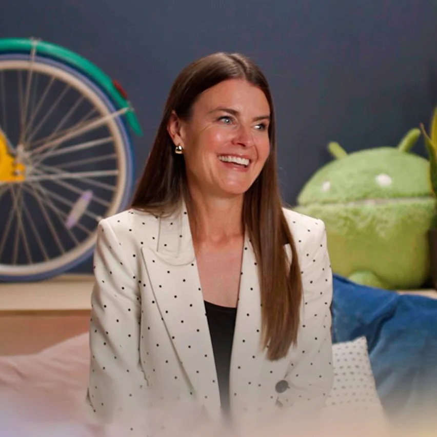 Woman in a blazer with bicycle in the background