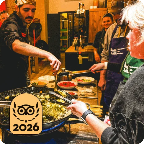 Image Description: Four people with bowls of ingredients learning how to make food. A gold 2026 Travelers’ Choice Best of the Best badge is on the image.