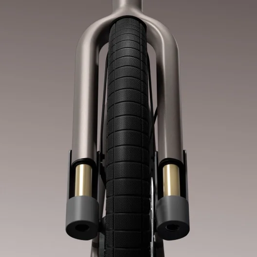 A straight-on view of the Cowboy e-bike’s front wheel and suspension fork. The gold suspension tubes stand out against the black tyre and sleek fork design.