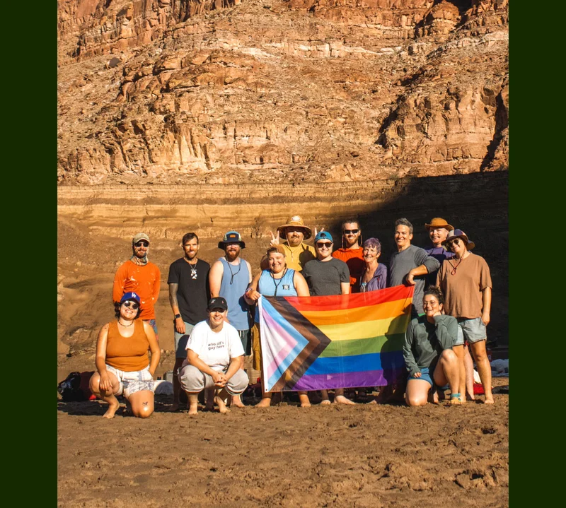 Venture Out Project holds Pride flag outside on mountain