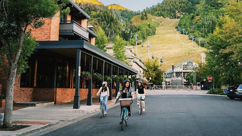 Image description: Three friends biking in downtown Aspen, Colorado