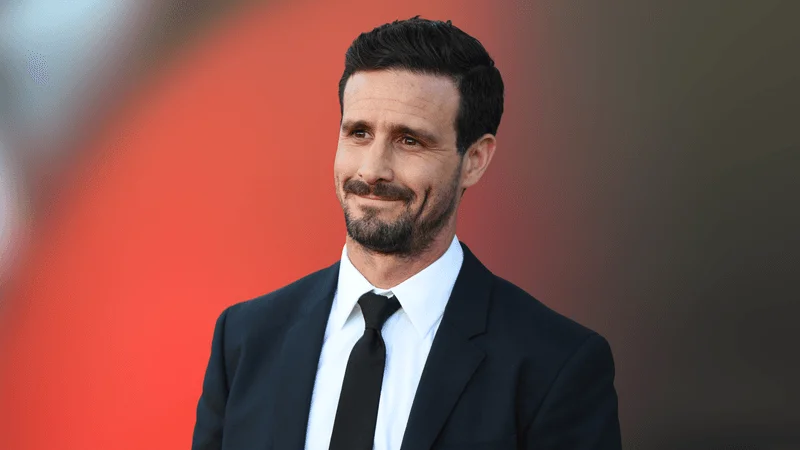 Image may contain: James Ransone, Accessories, Formal Wear, Tie, Clothing, Suit, Head, Person, Face, Adult, Happy, and Smile