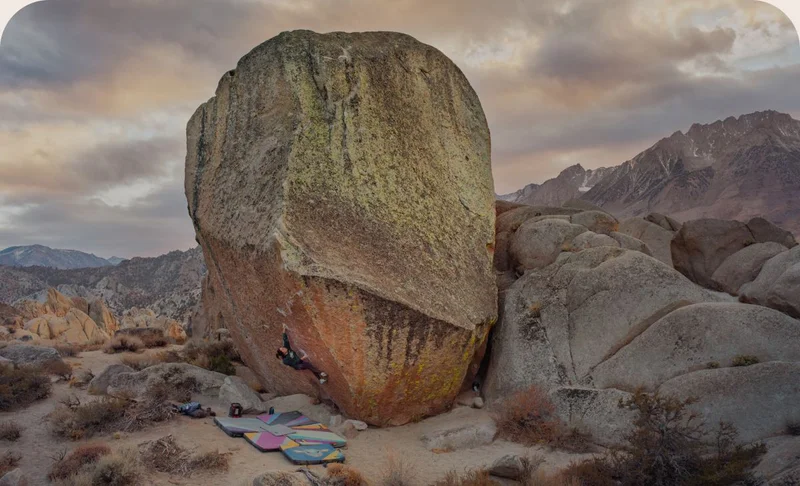 A climber begins a route on an enormous boulder.