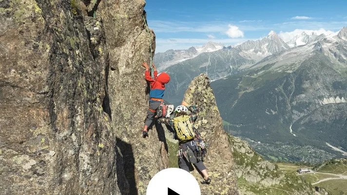 A parent and child rock climbing together.