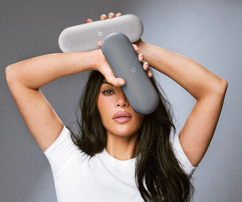 Kim Kardashian holding the limited edition Beats Pill speakers in Light Gray and Dark Gray.
