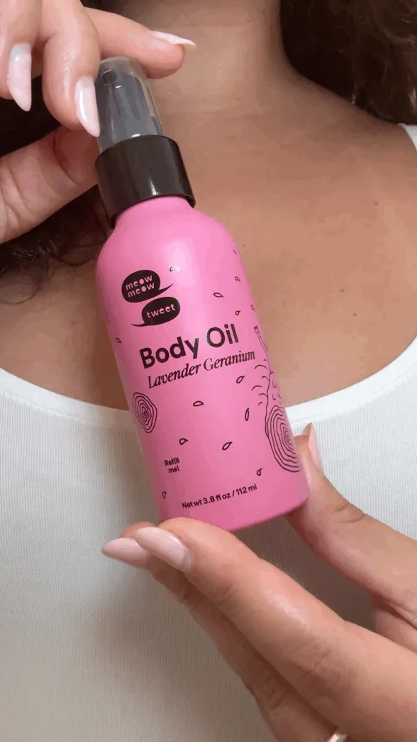 A hand shows off the pink body oil