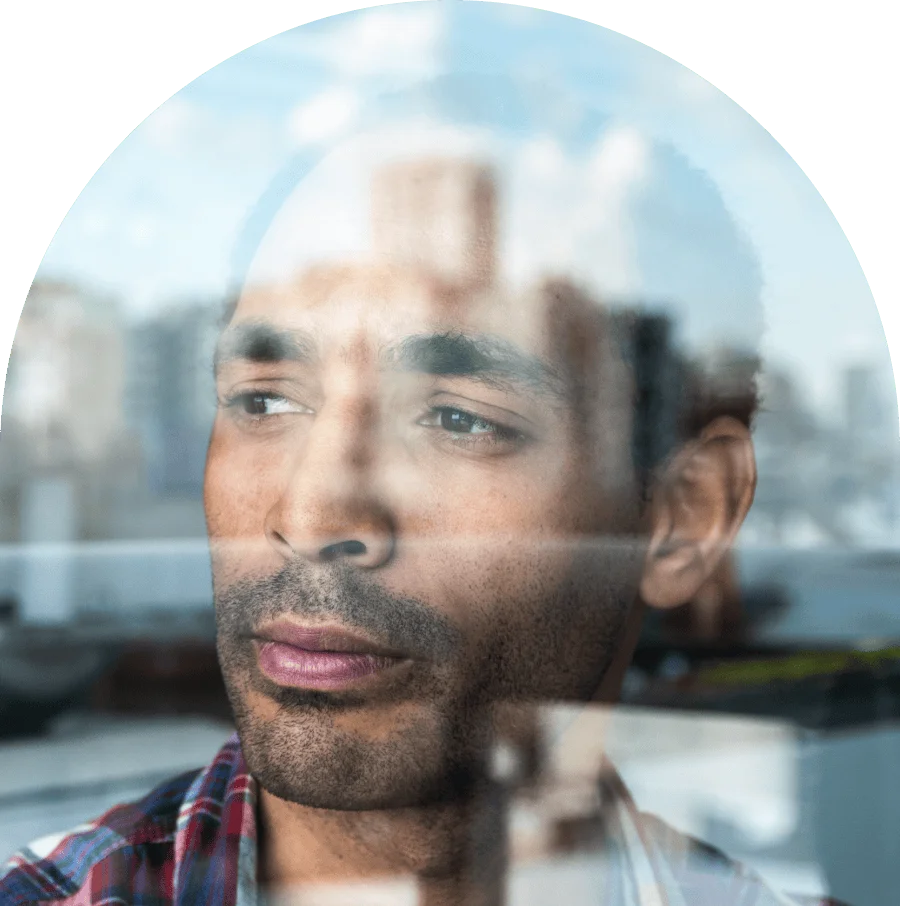 Mature man contemplating while look through window at home