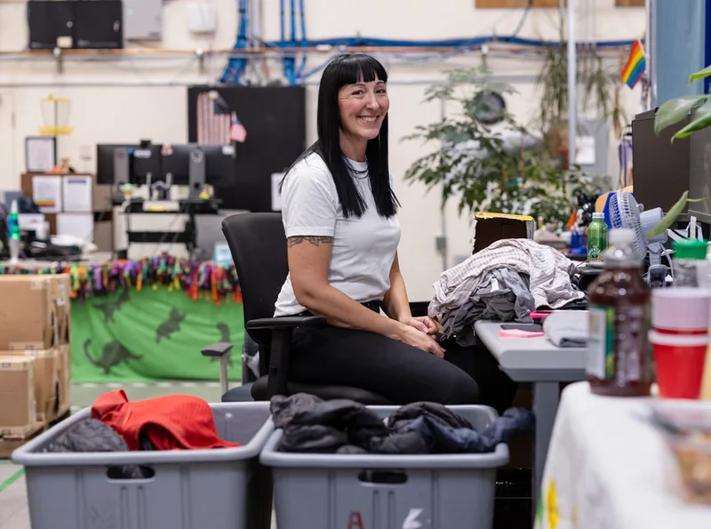 A person sorting clothing at their desk.