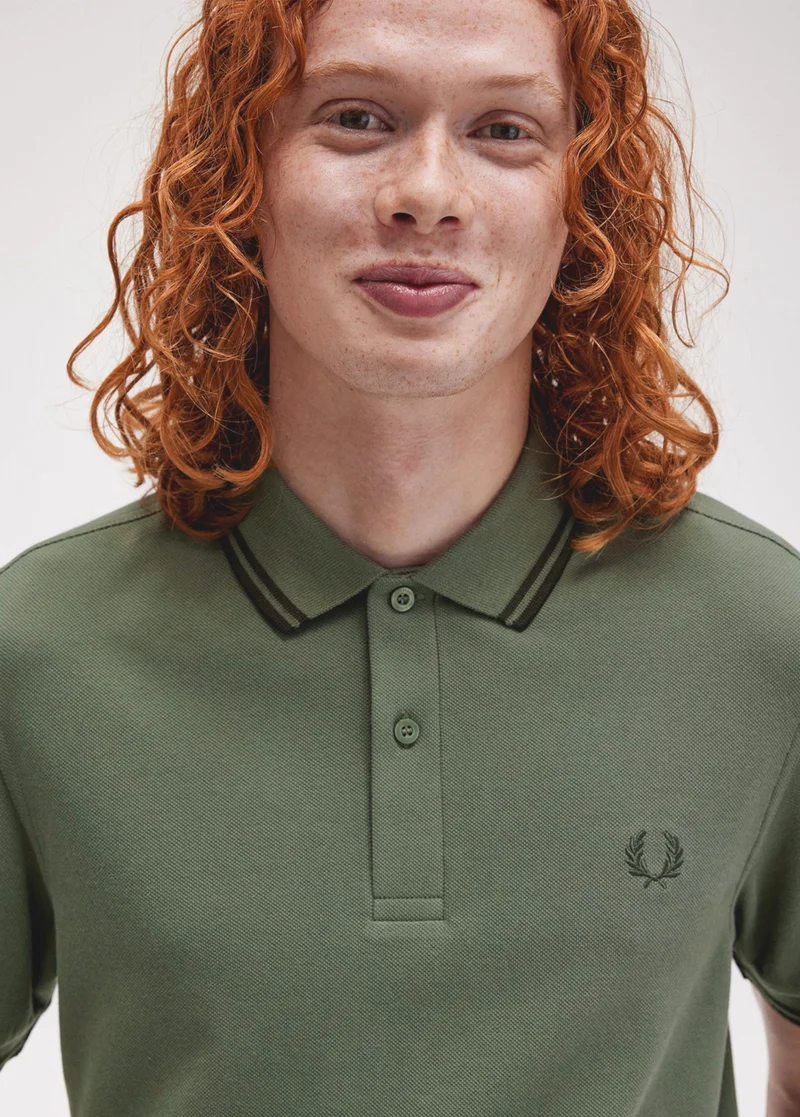 Man wearing green Fred Perry Shirt