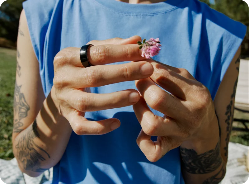 Person wearing Oura Ring holding flower