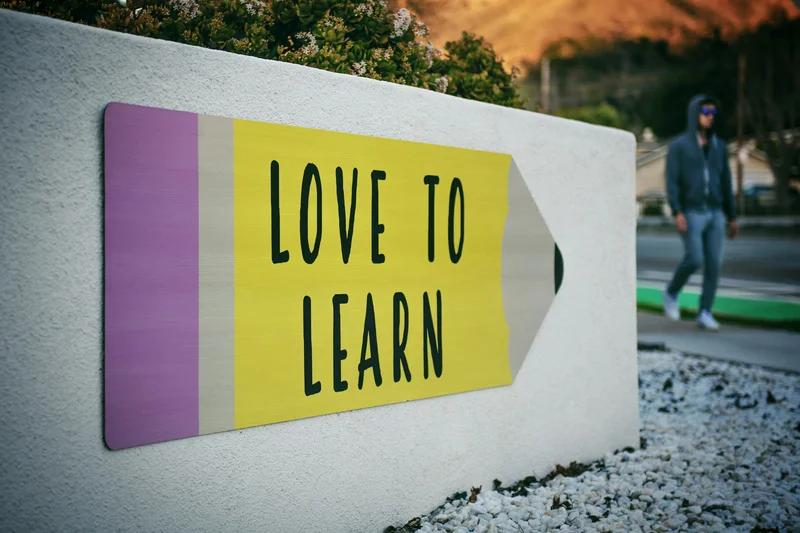 A sign in the shape of a pencil that says “Love to Learn.”