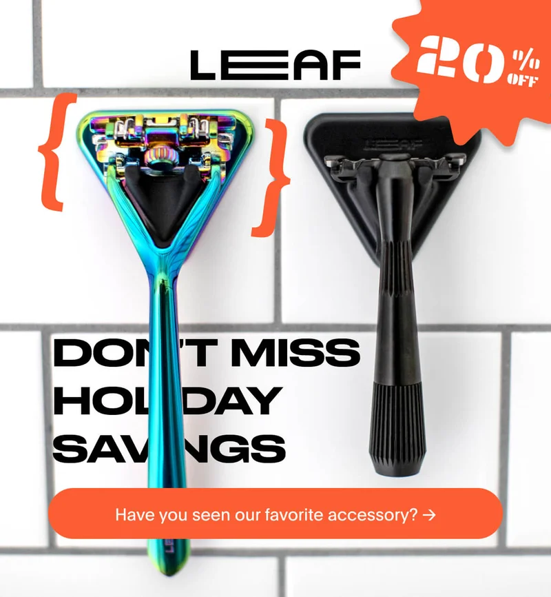 Two razors hanging on a tiled wall