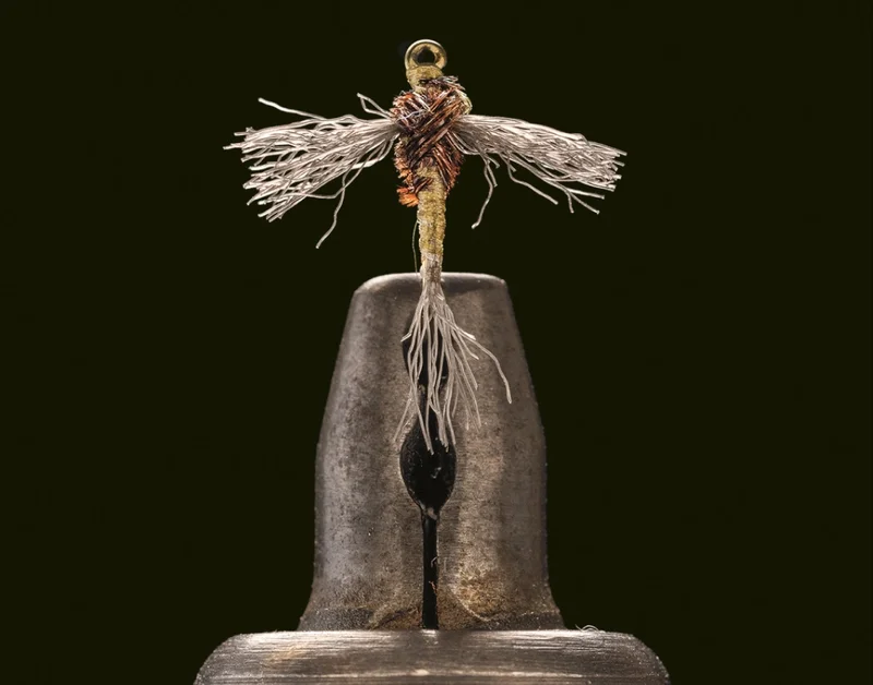 A hand-tied fly in a vice.