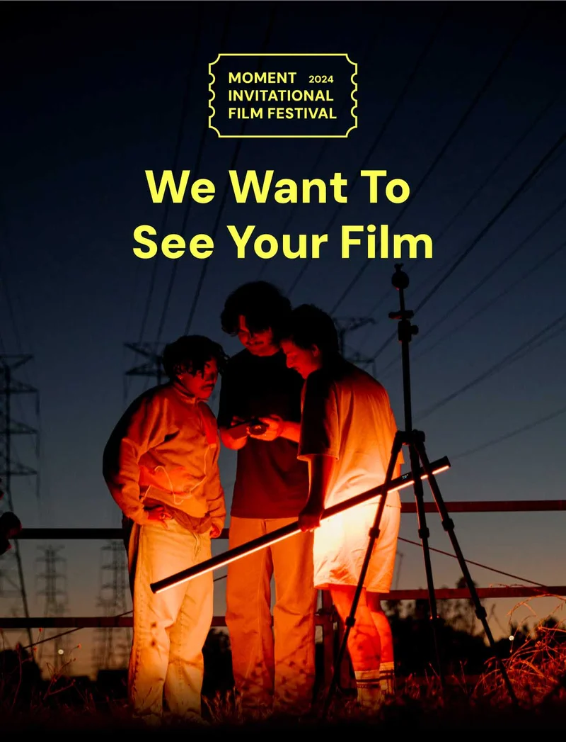 We Want to see your film - The Moment Invitational Film Festival - Image of 3 people looking at footage on their phone standing outside with a red tube light.