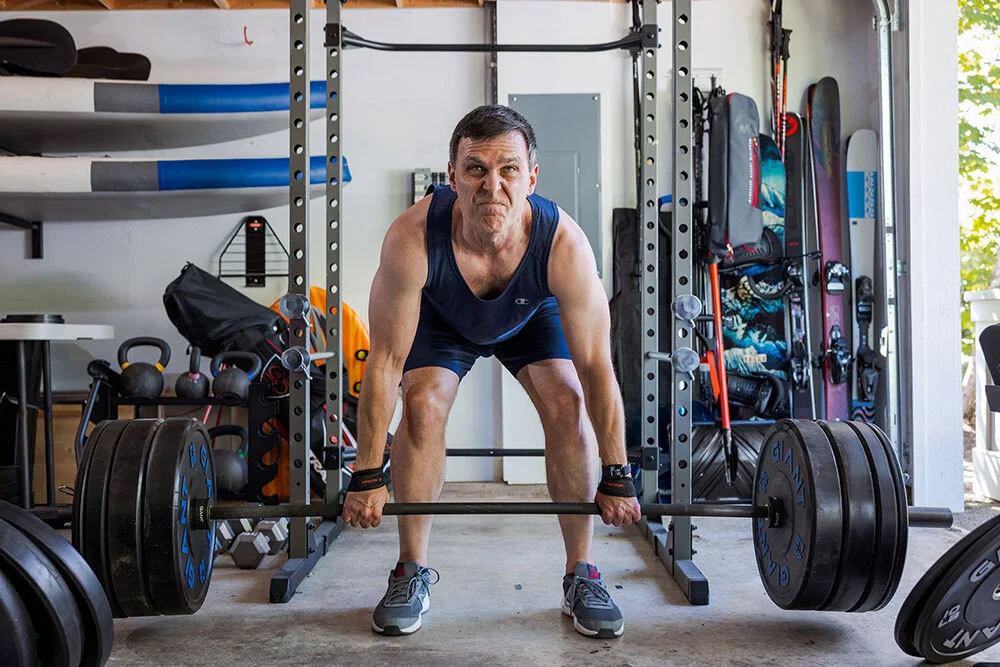 A man lifts weights. Many scientists say the key to preventing disease in old age is getting enough exercise, including weightlifting.