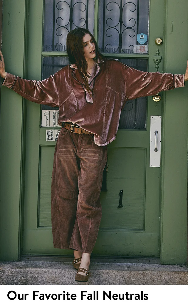 A woman wearing a brown top with brown jeans.