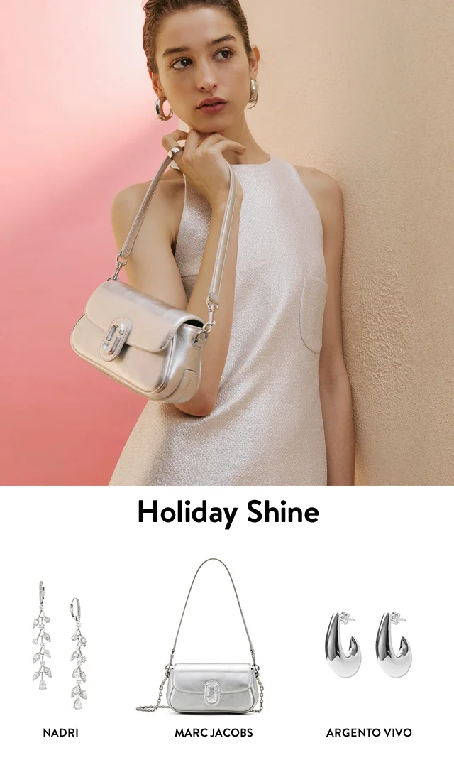 Woman wearing silver earrings and handbag. Silver hoop earrings, handbag and crystal drop earrings.