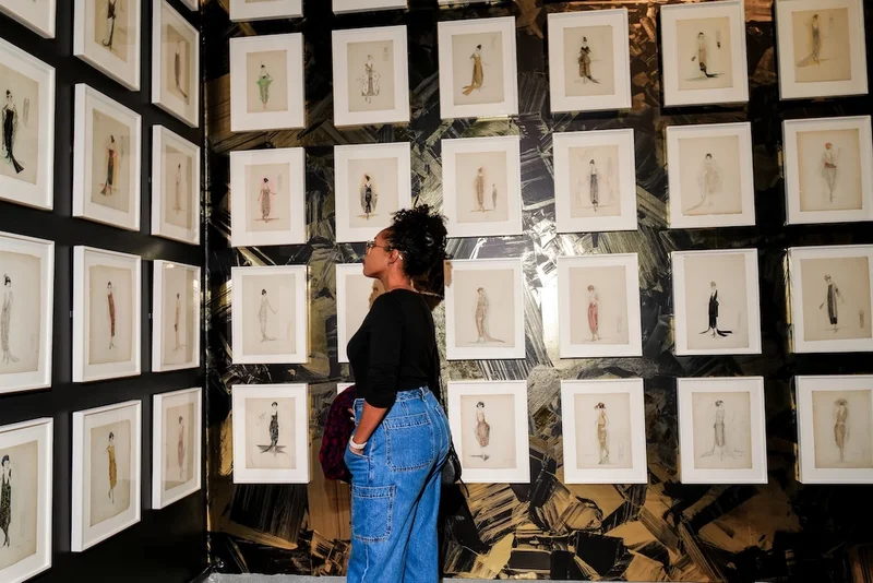 Person looking at a wall of fashion sketches