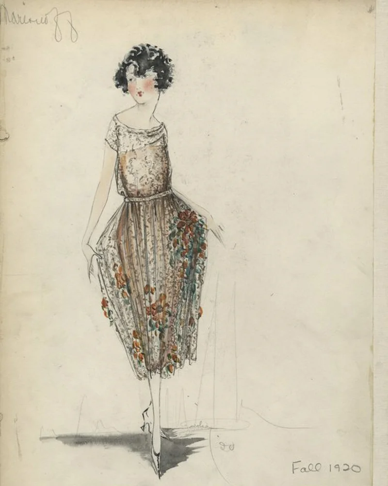 Sheer gold lace or net dress; knee-length skirt; bodice with bateau neck and cap sleeves; narrow belt; under slip or dress in orange; skirt with design of applied flowers in orange and green with gold and black details.