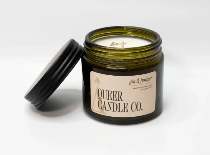 A candle with a label that reads "Queer Candle Co."
