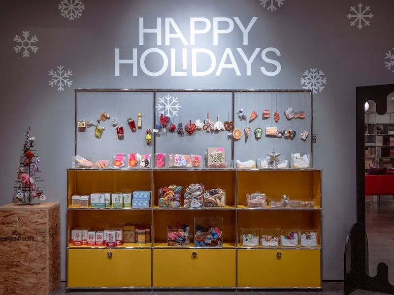 A wall of shop products under lettering reading "Happy holidays"