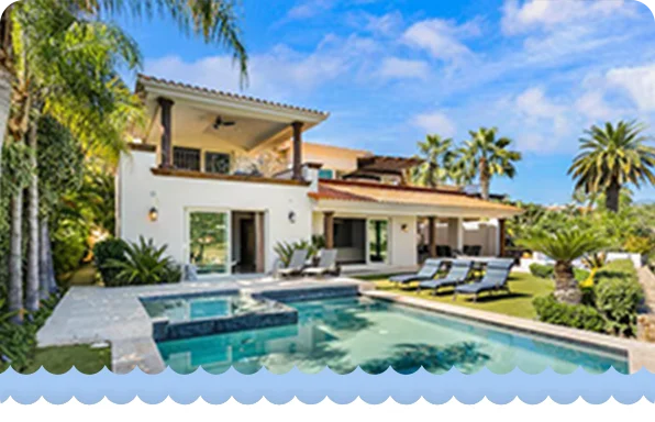Luxury villa with palm trees, sun loungers, and a pool featuring a raised spa area.