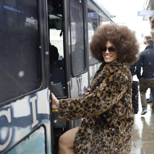 A smiling woman gets onto a Park City shuttle.