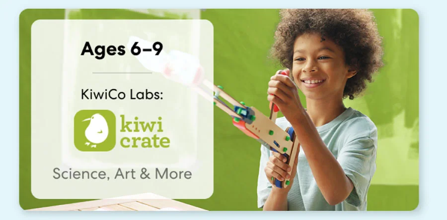 Young girl smiling while working on a science experiment from KiwiCo Labs. Hands-on STEM learning for ages 6–8.