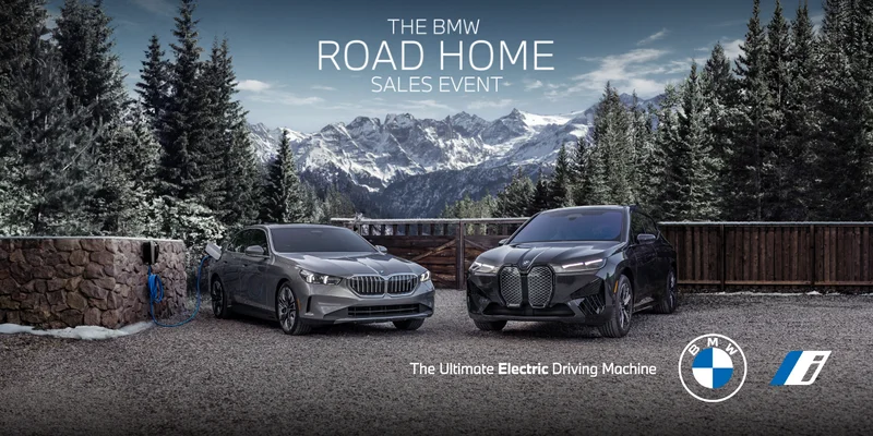The BMW i5 and iX parked in front of snow covered trees with mountains in the back. The BMW Summer On Sales Event. The Ultimate Electric Driving Machine. BMW i.