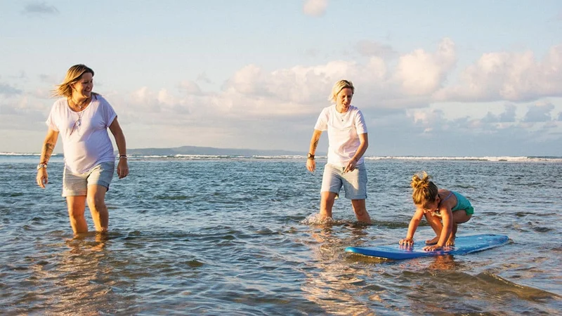 Image description: Family practicing surfing in San Diego.