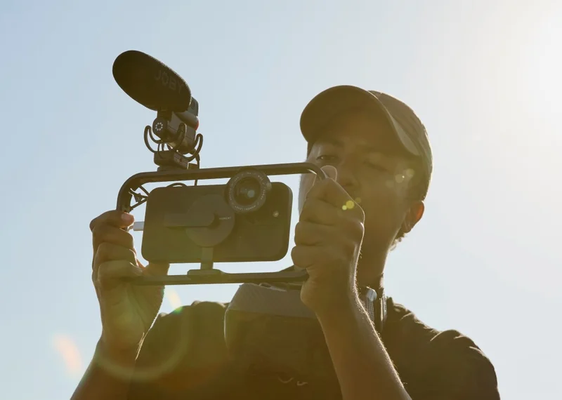 man filming with mobile phone and lens