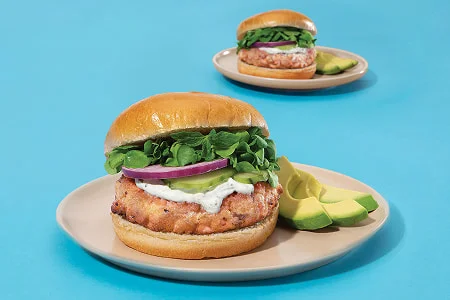 Healthy salmon burgers served on buns with vegetables