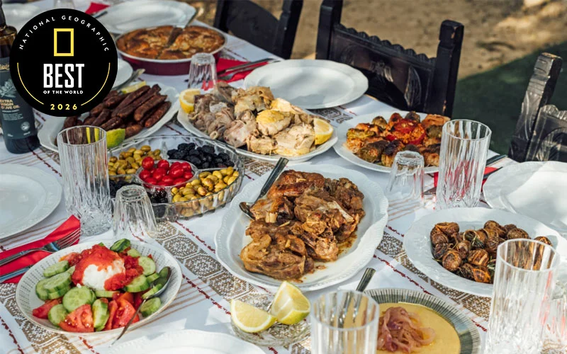 A table set with multiple dishes of Greek food